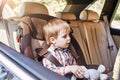 Boy sitting in a car in safety chair. Family road trip Royalty Free Stock Photo