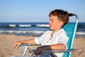 Boy sitting on chair at beach Royalty Free Stock Photo