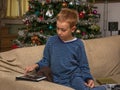 Boy Sitting on the Couch using a Tablet for letter for Christmas daddy, Christmas Tree in the background