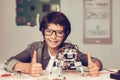 Boy Sitting at Desk and Constructing Robot at Home