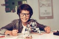 Boy Sitting at Desk and Constructing Robot at Home