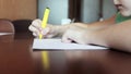 A boy sitting at desk and painting sketches with colorful marker on white paper