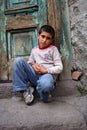 A boy sitting at the doorstep