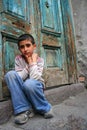 A boy sitting at the doorstep