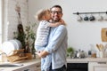 Boy sitting on fathers hands and kissing cheek