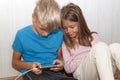 boy is sitting on floor and playing mobile games on his phone. girl sits next to him and worries about the process of playing a Royalty Free Stock Photo