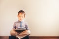 Boy sitting on the floor using a tablet absorbed in it Royalty Free Stock Photo