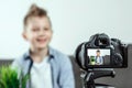 The boy is sitting in front of a SLR camera, close-up. Blogger, blogging, technology, earnings on the Internet. copy space