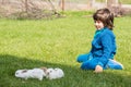 Boy sitting on grass with little rabbits