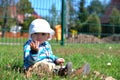 Small boy sitting on the grass at the playground