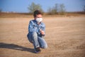 Boy is sitting on the ground in protective mask Royalty Free Stock Photo