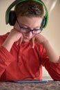 Boy sitting at home using his mobile phone with headphones Royalty Free Stock Photo