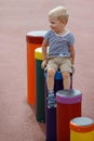 Boy sitting on a line of drums