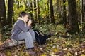 Boy sitting on log with cup sideview Royalty Free Stock Photo
