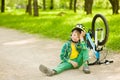 Boy sitting near a broken bicycle