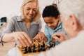 Boy sitting near of his parents and playing at chess with them Royalty Free Stock Photo