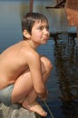 Boy sitting near water