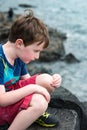 Boy sitting on the rocks at Giant`s Causeway