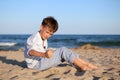 Boy sitting on sand at beach Royalty Free Stock Photo