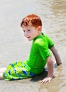 Boy sitting in shallow water Royalty Free Stock Photo