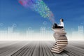 Boy sitting on stack of books with laptop Royalty Free Stock Photo