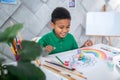 Boy sitting at table looking at pyramid of paints