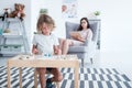 Boy sitting at the table and playing with building blocks while