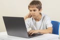Boy sitting at the table and using laptop computer Royalty Free Stock Photo