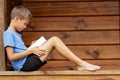 Boy sitting in terrace and reading book outdoor Royalty Free Stock Photo
