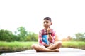 A boy sitting thinking on wooden bridge in the garden.