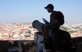 Boy sitting on top of a cannon above Lisbon in Castelo Sao Jorge