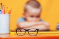 Boy sitting ubfocused glasses in focus. Concept problem of ophthalmology correction of myopia. back to school. Selective focus. Royalty Free Stock Photo