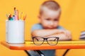 Boy sitting ubfocused glasses in focus. Concept problem of ophthalmology correction of myopia. back to school. Selective focus. Royalty Free Stock Photo