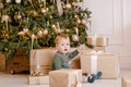 Boy sitting under Christmas tree with gift Royalty Free Stock Photo