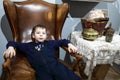 Boy sitting in vintage English leather chair