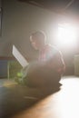 Boy sitting on wooden floor using laptop Royalty Free Stock Photo