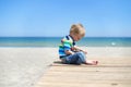 Boy sitting on a wooden walkway on the beach Royalty Free Stock Photo