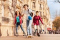 Boy skateboarding and girls rollerblading at city Royalty Free Stock Photo