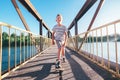 Boy skates on skate board on the bridge over tthe river Royalty Free Stock Photo