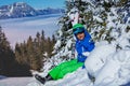 Boy with ski helmet and googles hold skies smile sit in snow Royalty Free Stock Photo