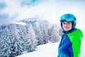 Boy in ski outfit smiling portrait over forest after snowfall Royalty Free Stock Photo