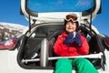 Boy skier sitting in car boot and drinking tea Royalty Free Stock Photo