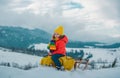 Boy sledding, enjoying sleigh ride. Child sitting on the sleigh. Children play with snow. Winter vacation concept. Royalty Free Stock Photo