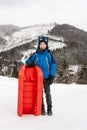 A boy with sledge in mountains Royalty Free Stock Photo
