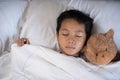 Boy sleeping on bed with teddy bear white pillow and sheets Royalty Free Stock Photo