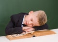 Boy sleeping on book in classroom Royalty Free Stock Photo