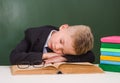 Boy sleeping on book in classroom Royalty Free Stock Photo