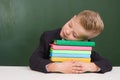 Boy sleeping on books in classroom Royalty Free Stock Photo