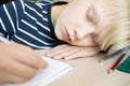 Boy sleeping while doing his homework in notebook. Royalty Free Stock Photo