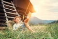 Boy sleeps in grass under hayloft in summer afternoon